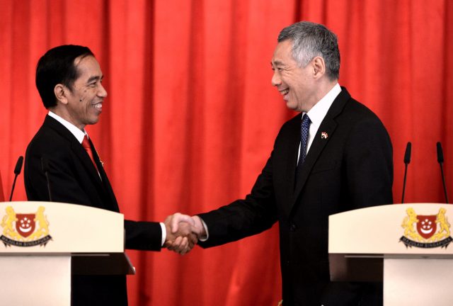 Presiden Joko Widodo (kiri) berjabat tangan dengan PM Singapura Lee Hsien Loong (kanan) usai memberikan pernyataan pers bersama di Singapura, Selasa (28/7).